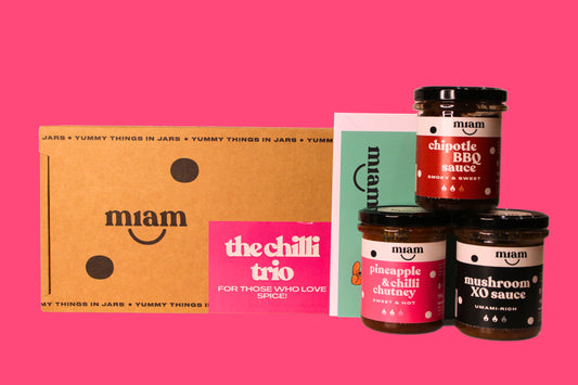 Miam sauce jars with a cardboard box on a pink background